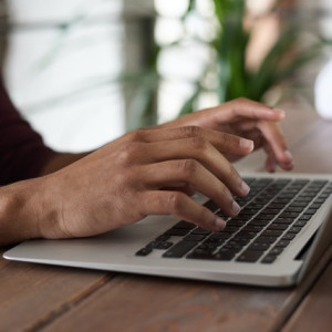 hands wooden desk laptop